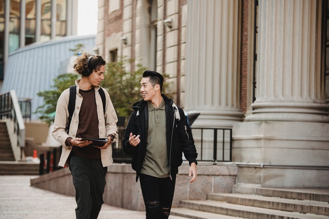 Photo by Armin Rimoldi: https://www.pexels.com/photo/multiracial-male-friends-talking-while-walking-down-street-5555112/ university or community college